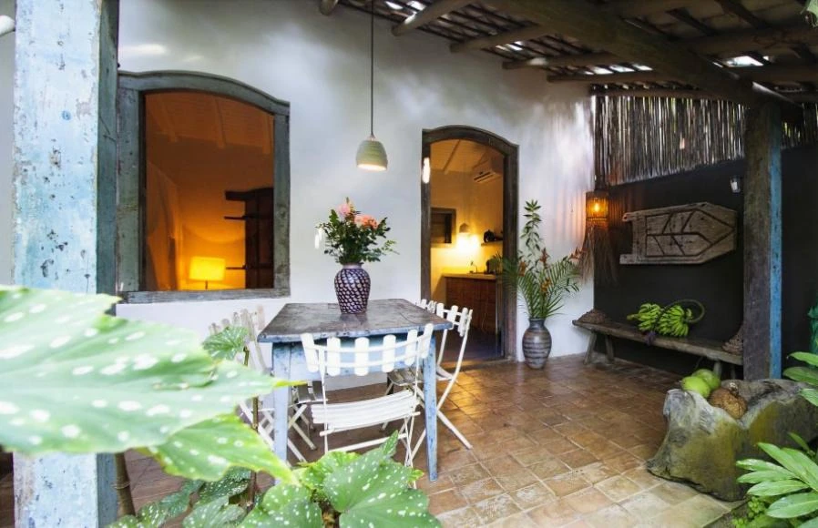 Pátio privativo de uma casa no UXUA, um dos mais charmosos hotéis boutique para casais no Brasil, com uma mesa e vista para o interior.