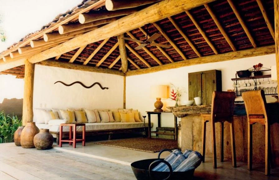 Sala de estar ao ar livre no UXUA Hotel, com design rústico e sofisticado, um exemplo perfeito de hospedagem de luxo para casais.