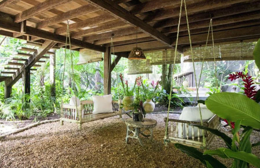 Balanços de madeira no jardim tranquilo do UXUA Hotel, o lugar perfeito para um momento de intimidade em um dos melhores hotéis boutique para casais no Brasil.